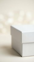 Minimalist white geometric blocks on neutral beige background with soft natural lighting and bokeh effect for modern design projects.