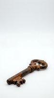 Antique rusty iron skeleton key isolated on white background, aged metal texture, vintage security concept.