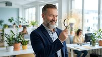 Mature businessman with beard holding light bulb in modern office workspace symbolizing innovation and creative business solutions.