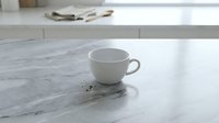 Empty white ceramic cup on marble countertop with scattered coffee beans, modern kitchen interior design, beverage and lifestyle concept for cafes and home decor.