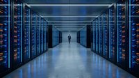 Modern data center corridor with server racks and silhouette of technician walking through blue-lit technology infrastructure for cloud computing concepts.