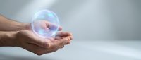 Male hand holding glowing transparent sphere with blue and pink light effects against neutral background. Concept for technology, innovation, future, and digital solutions.