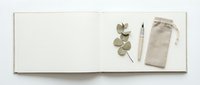Minimalist flat lay with eucalyptus branch, white pen and linen pouch on cream paper background for branding, stationery and natural lifestyle design.