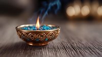 Decorative copper bowl with blue flame and smoke on wooden surface against blurred warm lights background creates mystical oriental atmosphere.