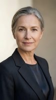 Confident mature businesswoman with gray hair in professional dark suit smiling at camera in corporate office setting for business leadership concepts.