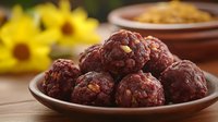 Homemade chocolate energy balls with nuts and dried fruits on ceramic plate, healthy snack food for breakfast or dessert on wooden table with sunflowers.