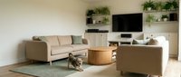 Modern minimalist living room interior with beige sectional sofa, wooden coffee table, wall-mounted TV and green plants for contemporary home decor.