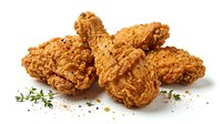 Crispy fried chicken pieces with golden breading and fresh herbs scattered on white background, ready for food photography and culinary design projects.