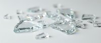 Scattered transparent glass shards and fragments on white surface, isolated design element for backgrounds, overlays, and digital compositions.