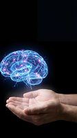 Glowing digital brain with neural networks floating above cupped hands on black background representing artificial intelligence and mental power.