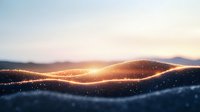 Glowing golden light waves flow across misty mountain silhouettes at sunset, creating magical atmosphere with sparkling particles in dark blue twilight sky.
