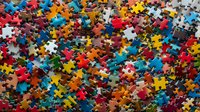 Colorful jigsaw puzzle pieces scattered randomly creating vibrant background pattern. Mixed red, blue, yellow and other bright colors for entertainment concept.