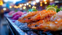 Fresh prawns on ice with colorful bokeh lights in background, close up view of seafood display at market or restaurant, selective focus on juicy shrimp.