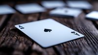 Ace of spades playing card on dark wooden table with dramatic lighting and shallow depth of field, creating mysterious gambling atmosphere.