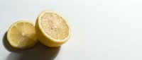 Fresh lemon halves cut in half showing juicy citrus flesh and segments on clean white background isolated for healthy cooking and vitamin C nutrition.