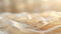 Flowing translucent fabric with soft golden light creating elegant waves and gentle folds for luxury textile and fashion design backgrounds.