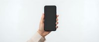 Female hand holding black smartphone with blank screen against white background for mockup and app presentation purposes.