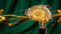 Creative brain-shaped light bulb glowing with golden filaments against dark green background symbolizing innovation, intelligence and bright ideas for business concepts.