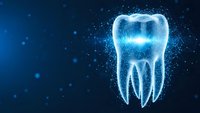 Futuristic digital tooth hologram with glowing particles on blue background for dental technology and healthcare innovation concepts.