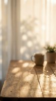 Warm sunlight streaming through window onto rustic wooden table with coffee mug and plant pot creating peaceful morning atmosphere for relaxation and mindfulness.