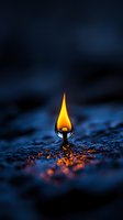 Single bright flame emerging from water surface creates dramatic contrast against dark blue background, with glowing reflections rippling across wet surface.