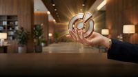 Businessman holding glowing target symbol with light rays in modern office lobby, representing business goals, strategy, and success achievement.