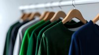 Colorful casual shirts hanging on wooden hangers in closet wardrobe. Organized clothing collection for fashion retail store or personal style choices.