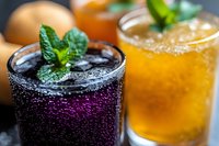 Refreshing summer cocktails with mint garnish and sparkling bubbles on dark background. Colorful drinks for bar menu and beverage photography.