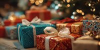 Festive wrapped Christmas presents with glittery paper and ribbon bows on wooden surface against blurred holiday lights background.