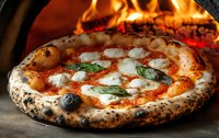 Traditional Neapolitan pizza with melted mozzarella, tomato sauce and fresh basil leaves baking in wood-fired brick oven with visible flames and charred crust.