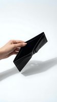 Hand holding empty black leather wallet showing financial crisis and bankruptcy concept on white background for business presentations.