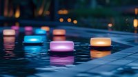 Colorful floating candles glowing on dark water surface at night creating peaceful ambiance for spa relaxation meditation and romantic evening atmosphere.