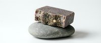 Stacked stones with decorative metallic element on white background, isolated for design projects, spa and wellness concepts.