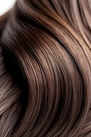 Close-up of glossy brown hair with highlights showing smooth waves and texture, useful for beauty and haircare advertising.