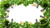 Leprechaun hats, horseshoes, and gold coins arranged in a circular frame with shamrock clover leaves on white background for St. Patrick's Day celebrations and festive designs.