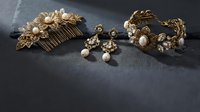 Elegant gold bridal jewelry set with pearls and crystals on dark slate background for wedding accessories and luxury fashion styling.
