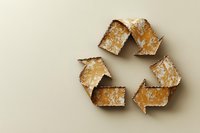Recycling symbol made from rusty corroded metal arrows on neutral beige background, showing environmental decay and sustainability concept.