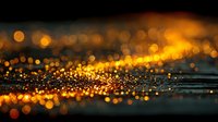Abstract golden bokeh lights with sparkling particles on dark surface creating warm atmospheric glow for luxury backgrounds and elegant design projects.