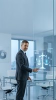 Professional businessman in suit using futuristic holographic legal tech interface with scales of justice in modern office conference room.