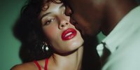 Young woman with curly hair and red lipstick in intimate moment with partner, romantic couple lifestyle photography for relationship and dating concepts.