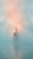 Silhouetted figure standing in misty water with ethereal golden light creating a mystical, dreamlike atmosphere for spiritual and conceptual projects.