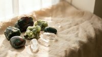 Collection of healing crystals and gemstones arranged on soft fabric in natural sunlight for meditation, wellness practices, and spiritual energy work.