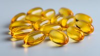 Golden omega-3 fish oil capsules arranged on white surface, showcasing translucent yellow gel supplements for health and nutrition benefits.
