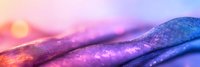 Vibrant abstract macro landscape with rolling curves in purple and pink hues against soft bokeh background creates dreamy artistic composition for creative designs.