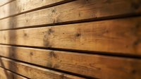 Natural wood planks with rustic texture and visible grain patterns creating warm brown wooden surface for construction and interior design projects.