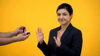 Professional businesswoman refusing cigarette offer with hand gesture promoting healthy lifestyle choices against bright yellow background.