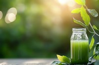 Fresh green smoothie in glass mason jar surrounded by natural leaves and sunlight bokeh, healthy detox drink for wellness and nutrition.