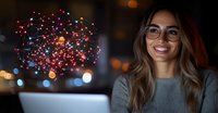 Young Hispanic woman with glasses smiling while working on laptop at night, with colorful network visualization hologram floating in dark room with bokeh lights.
