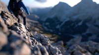 Dramatic mountain climbing scene with climber silhouette against rugged rocky terrain and misty peaks at sunrise, capturing adventure and exploration spirit.