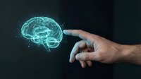 Human hand reaching toward glowing digital brain hologram on dark background representing artificial intelligence, neuroscience and cognitive technology concepts.